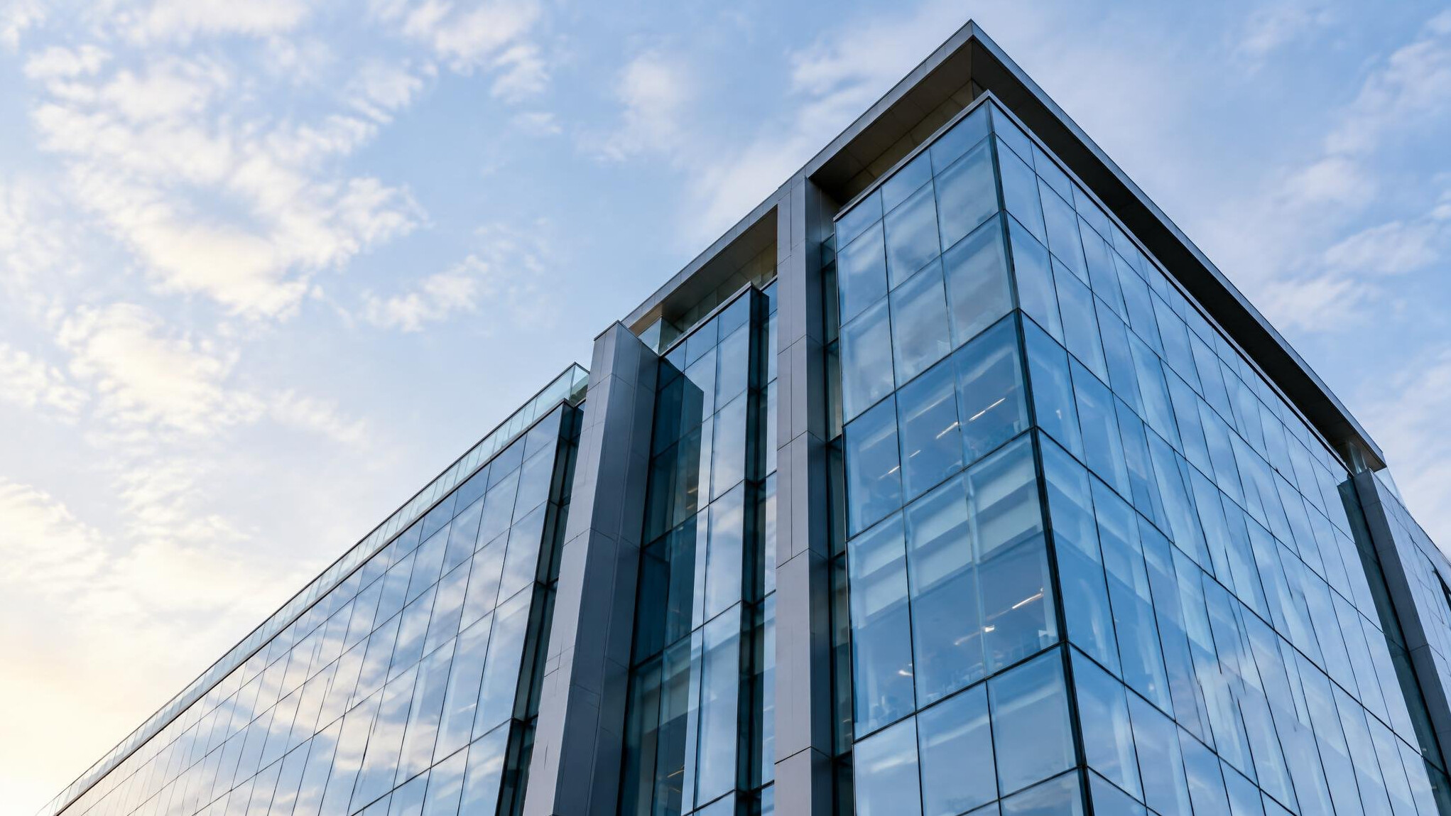 Modern glass office building facade seen from below
