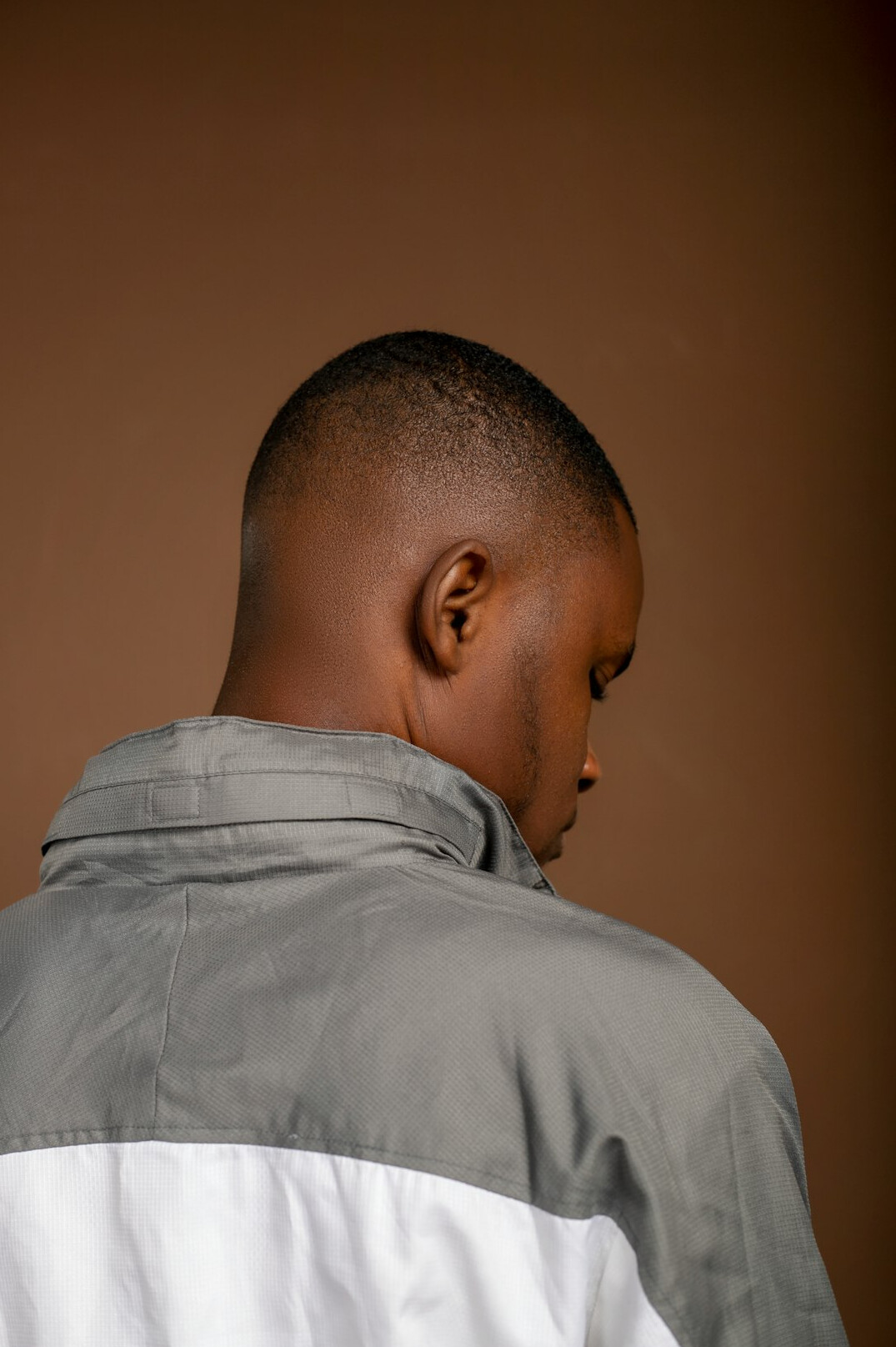 Portrait of a man with short hair in a casual shirt, neutral background